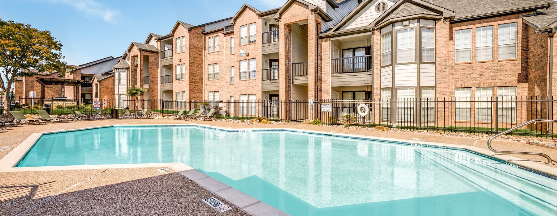 a swimming pool in front of a large building