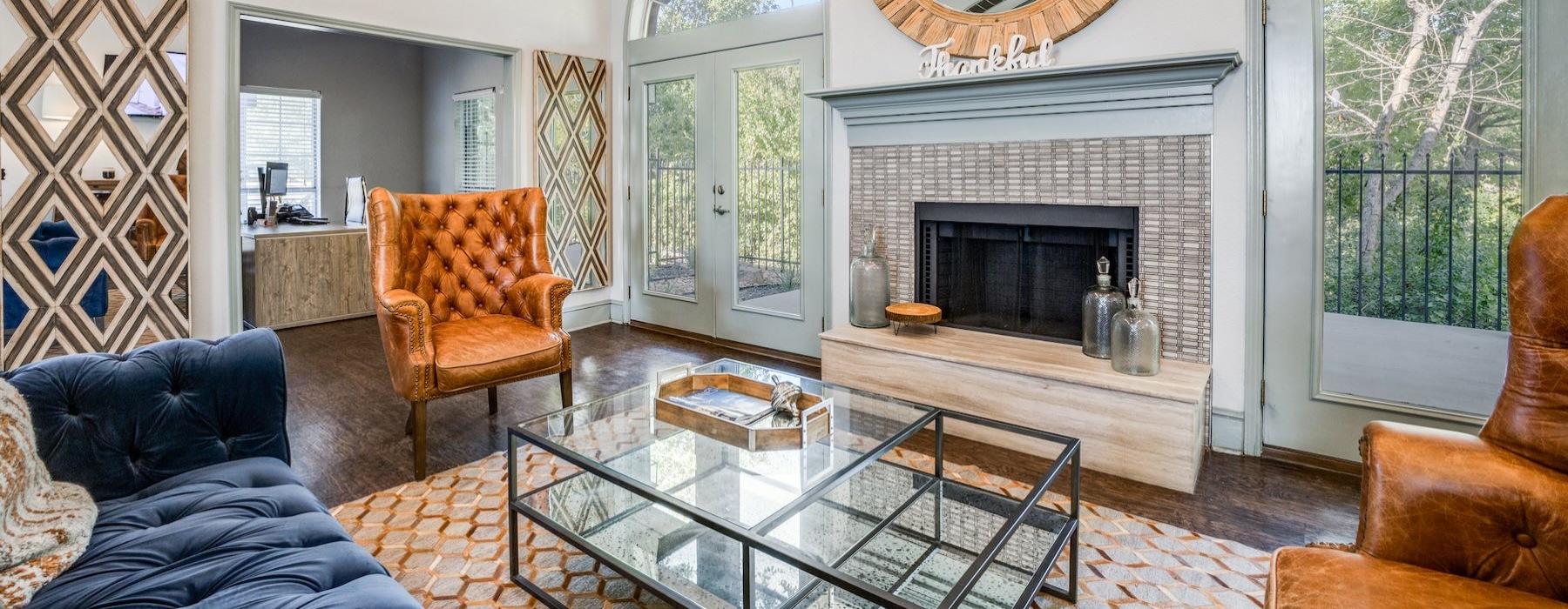 a clubroom with a fireplace, a couch, a chair and a coffee table